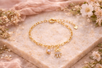 Children's bracelet with a pearl pendant and a teddy bear studded with micro cubic zirconia, plated in hypoallergenic 18k gold.
