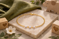 Children's bracelet with three small pearls in the center separated by spaces, 18k gold plated, hypoallergenic.