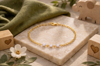 Children's bracelet with three small pearls in the center separated by spaces, 18k gold plated, hypoallergenic.